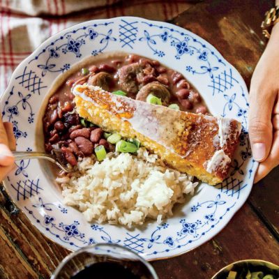 a plate of emily's red beans and rice with a side of corn bread