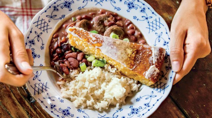 a plate of emily's red beans and rice with a side of corn bread