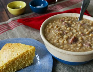 a bowl of lady cream peas with chisesi ham and a side of corn bread