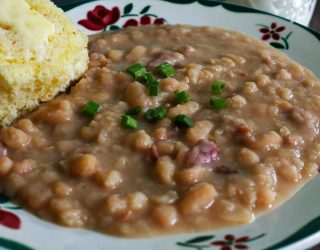 great northern beans on a plate with a side of corn bread