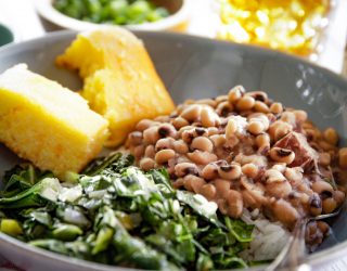 a plate of blackeye peas and a side of collard greens and corn bread