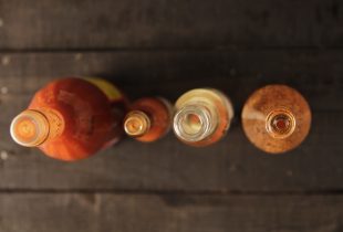 a top/down view of 4 different bottles of hot sauce