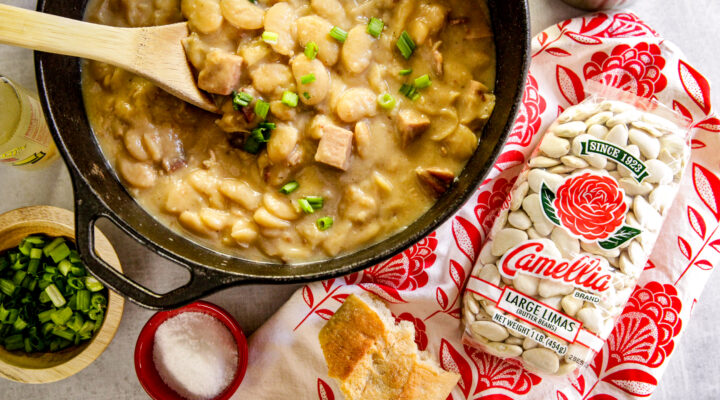 Simple Lima Beans inside a cast iron pan and a bag of large lima beans placed on the side