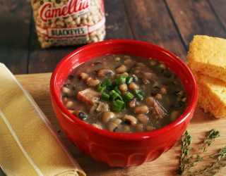 a bowl of Hayward Family's Blackeye Peas with a side of corn bread and a package of blackeyes