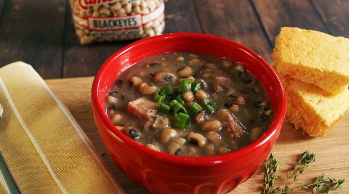 a bowl of Hayward Family's Blackeye Peas with a side of corn bread and a package of blackeyes