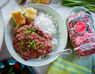 Plated red beans and rice with french bread. A bag of 1 pound red kidney beans on the side.
