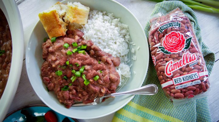 Plated red beans and rice with french bread. A bag of 1 pound red kidney beans on the side.