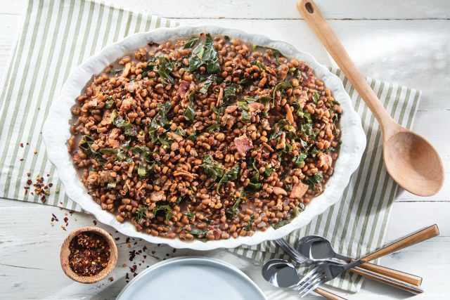 a big bowl of bourbon bacon field peas with collard greens