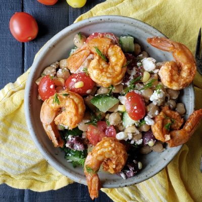 a close up of a bowl of garbanzo summer salad with shrimp and feta cheese