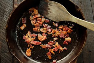 bacon cooking in bacon grease in cast iron skillet