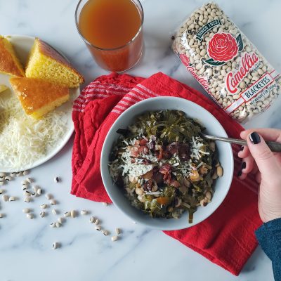 a bowl of Potlikker next to a package of camellia brand black eyes and a side of cornbread