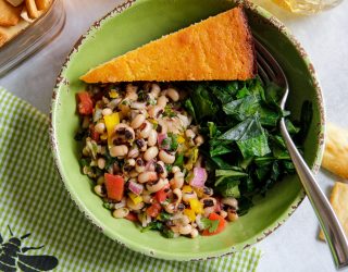 a bowl of cowboy caviar with greens and cornbread