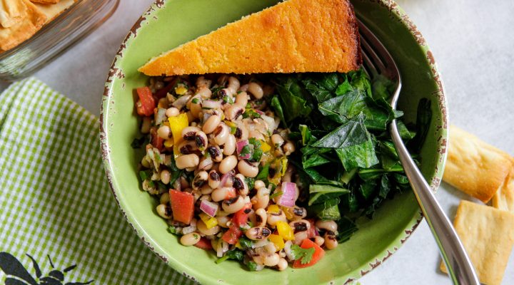 a bowl of cowboy caviar with greens and cornbread
