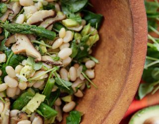 Summer/Spring white bean salad with asparagas and mushrooms in a wooden bowl