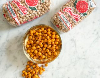 a bowl of texas honey chickpea garganzo with 2 packaged of camellia brand garbanzo beans in the background