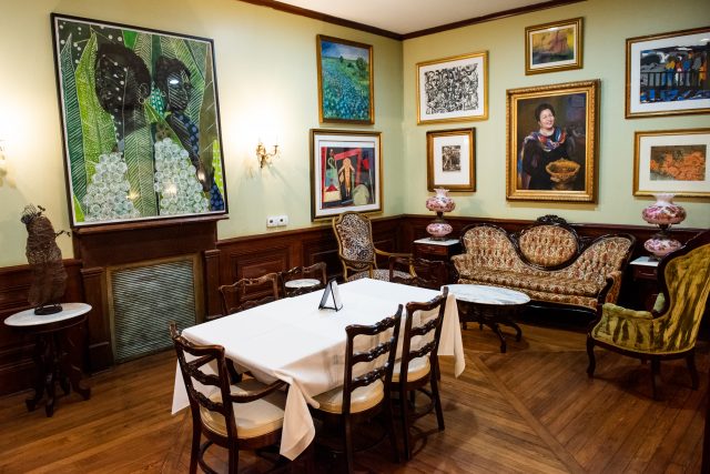 Dining area in Dooky Chase's restaurant with art adorned on the walls and plenty of seating