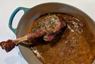 a dutch oven with red beans and a giant turkey leg