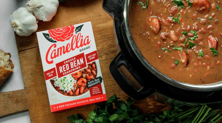overhead image of cooked instant pot full of red beans next to box of creole red beans seasoning product