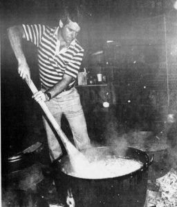 a young camp stew cook tending to his kettle in the early 1980s