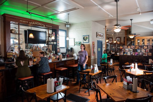 Customers sitting and walking inside of Mahony's restaurant.