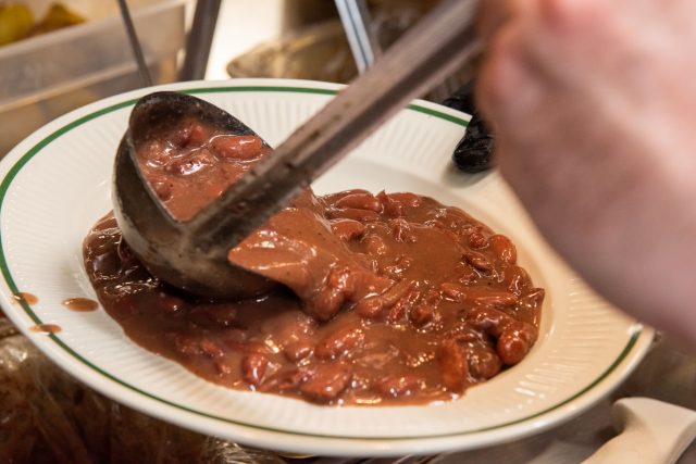 Chef at Mahony's scooping red beans onto a plate.