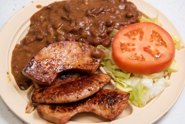 A plate of red beans, rice, grilled sausage and side salad