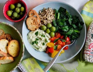 a mediterranean bowl wwith an assortment of meditteranean food in it