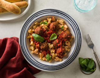 a bowl of kid friendly vegan meatballs and pasta that is crawfish shaped