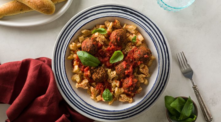 a bowl of kid friendly vegan meatballs and pasta that is crawfish shaped