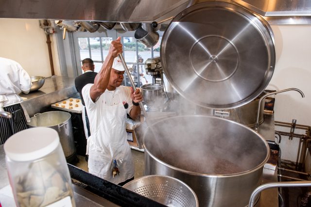 Stirring red beans inside a giant pot