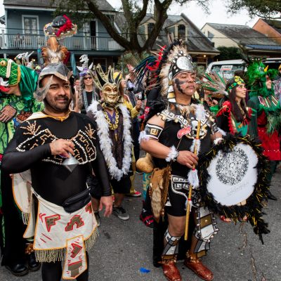 group of people in a Lundi Gras marching parade, costumed