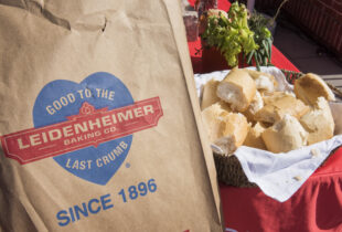 close up of a brown plastic bag from leidenheimer with its logo on it next to a basket of french bread