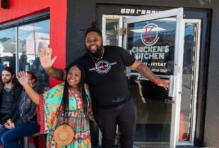 the owners of chicken's kitchen in front of their restaurant chicken's kitchen