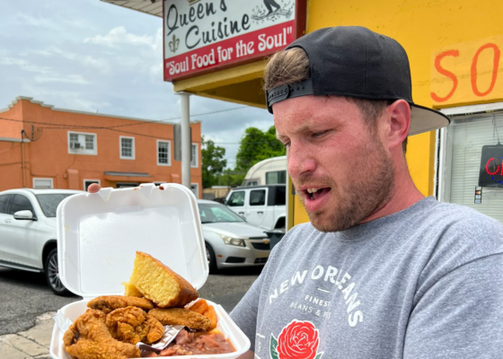 Devin Snow holding a to-go container of red beans and rice with cornbread