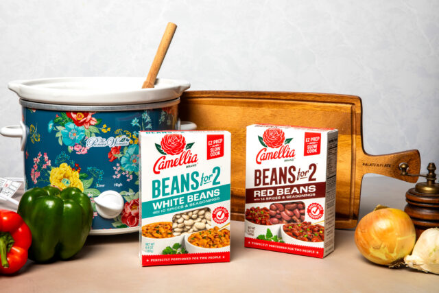 Beans for 2 boxes in front of cutting board, crockpot and onions and bell peppers