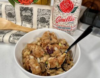 Sourdough Stuffing with White Beans in a white bowl on a table next to bag of beans