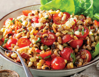 prepared Blackeye Pea Salad with Smoky Sorghum Dressing in a white bowl with spoon and garnish