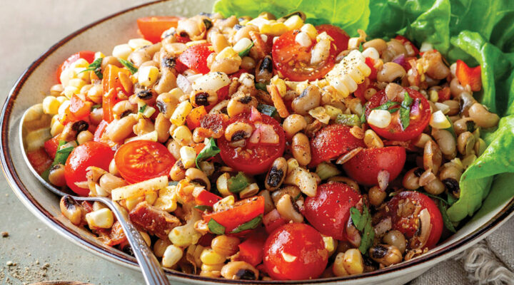 prepared Blackeye Pea Salad with Smoky Sorghum Dressing in a white bowl with spoon and garnish