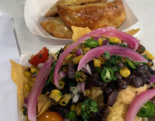 close up of pickled red onions on top of plate of nachos