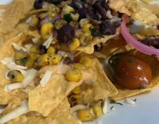 close up image of nachos with roasted corn salsa on top