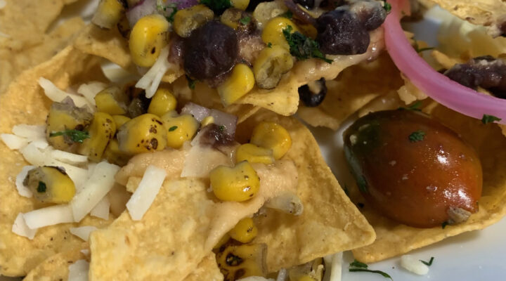 close up image of nachos with roasted corn salsa on top