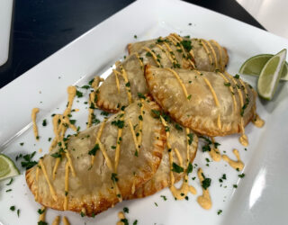 Plate of cooked Pinto Beans and Rajas de Chiles Empanadas with garnishes