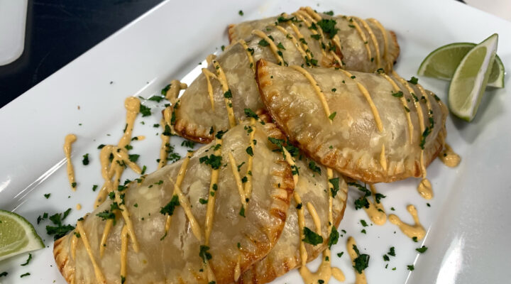 Plate of cooked Pinto Beans and Rajas de Chiles Empanadas with garnishes