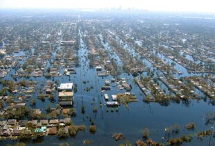 Aerial flooding of New Orleans. Home almost completely under water with only the roofs showing.