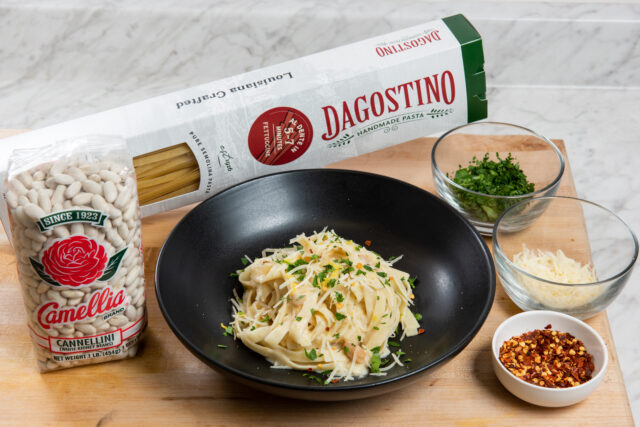 Pasta in a black bowl in front of a box of pasta