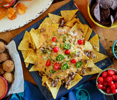 A spread of nachos, chips, and assorted dishes arranged on a table, inviting for a casual meal or gathering.