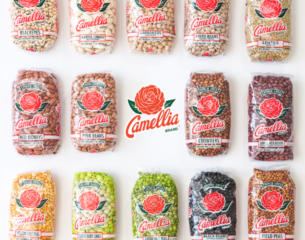 Fourteen bags of Camellia brand beans and peas are arranged in a grid. Each bag features a red logo with a camellia flower, conveying variety and freshness.