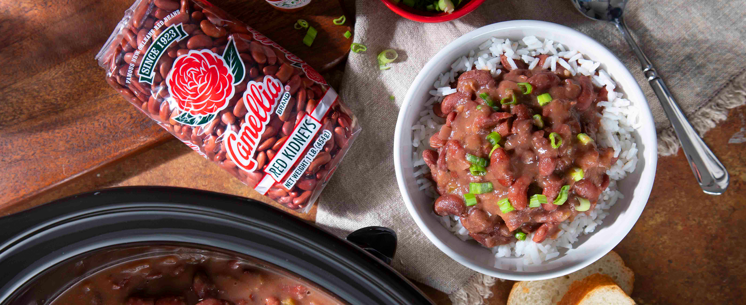 Camellia Brand Red Kidney Beans in a package next to a bowl of red beans and rice